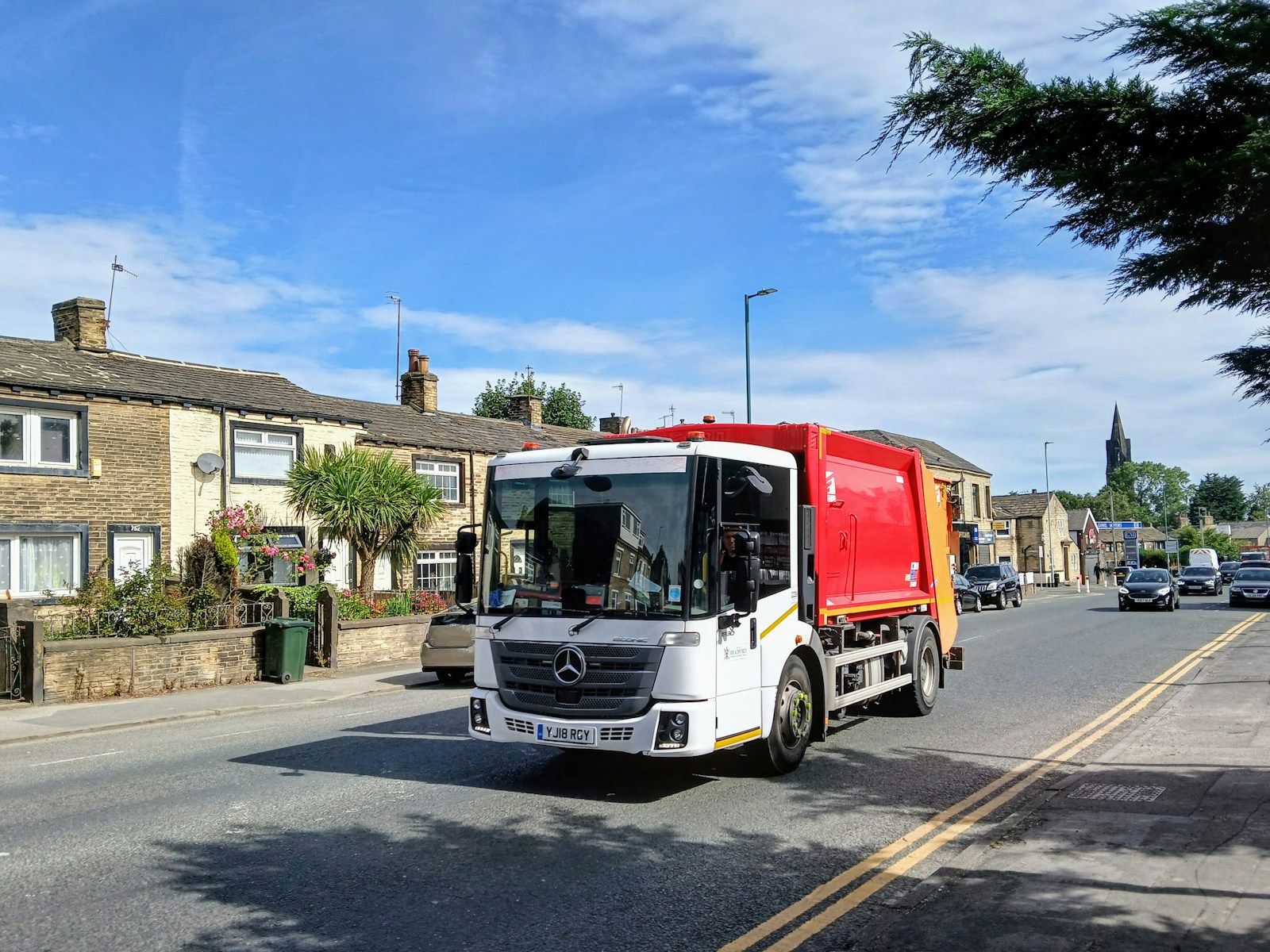 A red and white truck driving down a street